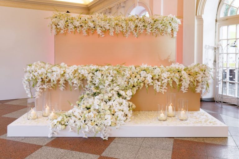 Brauttisch mit aussergewoehnlicher Blumendekoration auf einem Podest 768x512